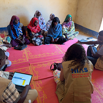 HIAS workers sitting on the floors with women in need. Links to What to Give HIAS workers sitting on the floors with women in need. Links to What to Give